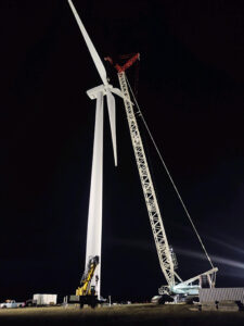 carne lifting wind turbine at night